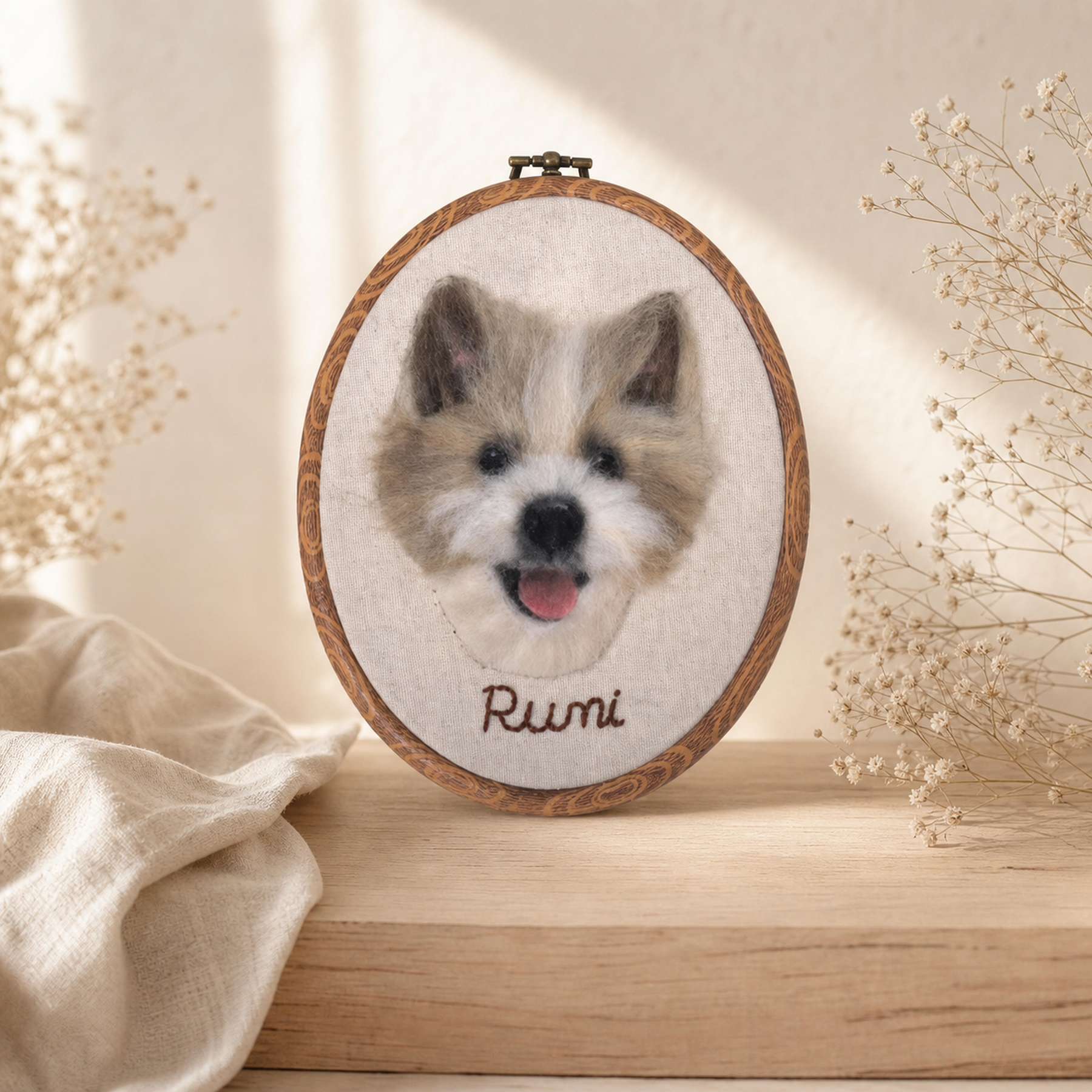 Rumi, a smiling dog, recreated as a wool felt portrait